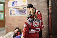 2 Personen vom DRK helfen einer obdachlosen Person